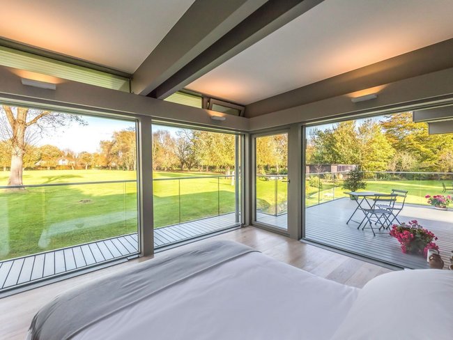 Stilvoller HUF Anbau mit harmonischem Wohnraum Modernes Schlafzimmer mit Blick auf den Garten und elegante Architektur