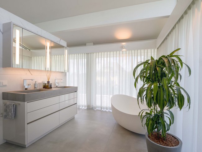 Elegantes Badezimmer mit Badewanne und großen Fenstern