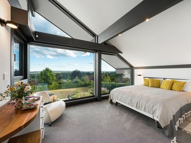 Modernes Schlafzimmer mit großen Fenstern und entspannender Aussicht