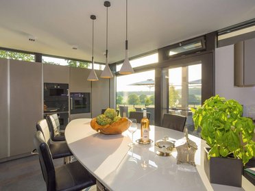 Moderne Küche mit elegantem Design und Naturblick Stilvolle Küche mit minimalistischer Gestaltung und Aussicht auf die Natur