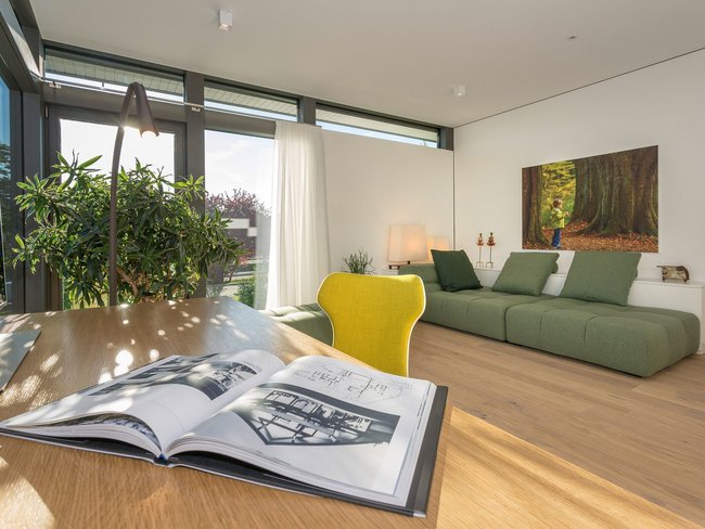 Moderne Wohnung mit gemütlichem Ambiente Ein heller Raum mit Sofa, Tisch und großen Fenstern.
