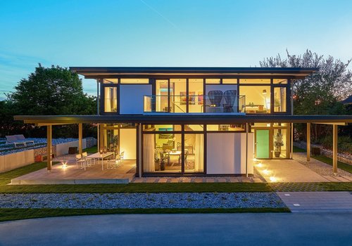Zweistöckiges Wohnhaus mit großflächigen Fenstern und Garten