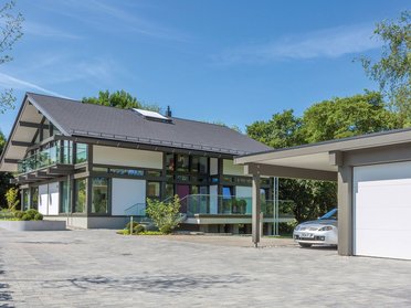 Ansicht eines modernen Hauses mit Carport und klarem blauen Himmel