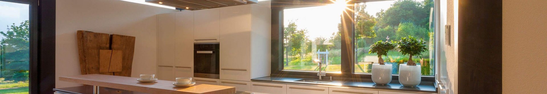 Helle Küche mit Holzdetails und großem Fenster im Sonnenlicht
