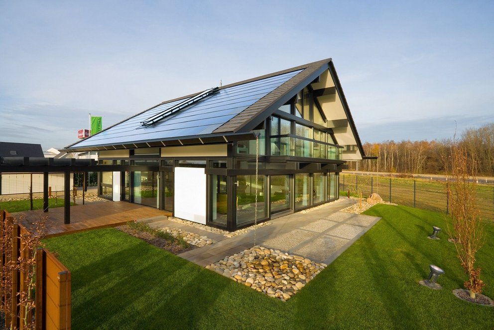 Moderne Architektur mit Solarpanelen und Garten Ein modernes Haus mit Glasfront, Solarpanelen und gepflegtem Garten