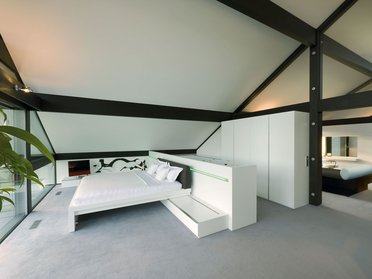 Heller Raum mit Doppelbett und modernem Design, große Fenster