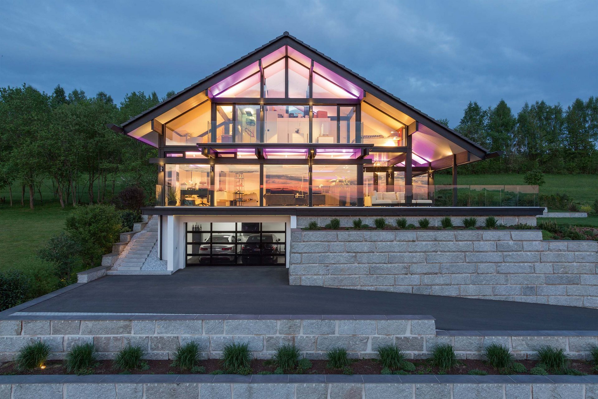 Moderne Villa mit Glasfassade und bunten Lichtern Architektonisches Design einer modernen Villa in der Natur