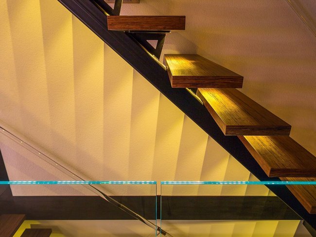 Moderne Treppe in einem Fachwerkhaus aus Holz und Glas Helle Treppenstufen mit LED-Beleuchtung in einem stilvollen Haus