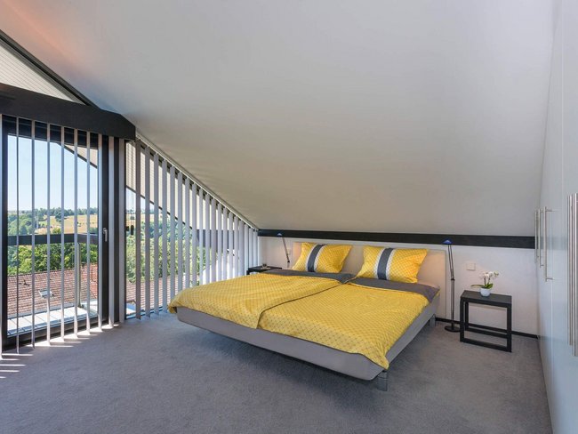 Gemütliches Schlafzimmer mit Doppelbett und Aussicht auf die Natur.