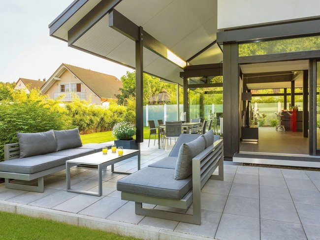Geräumige Terrasse mit modernem Mobiliar und Gartenansicht