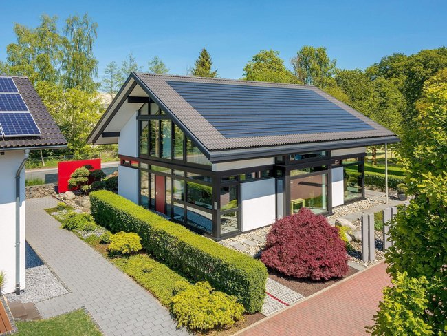 Moderne Architektur eines Einfamilienhauses im Grünen Einfamilienhaus mit Garten, Solarpanel und schöner Landschaft