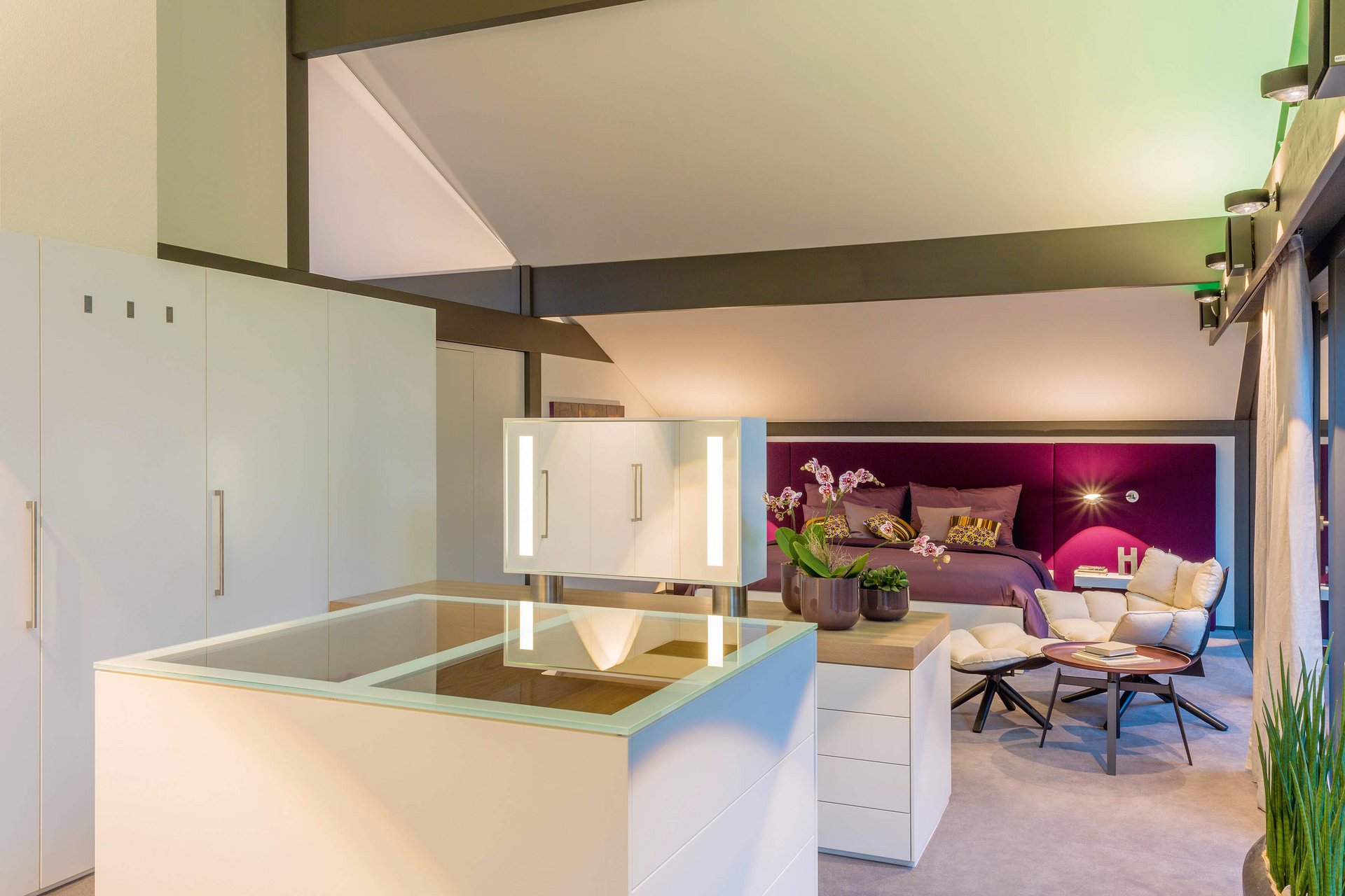 Elegantes Schlafzimmer mit weißen Möbeln und gemütlicher Sitzgelegenheit
