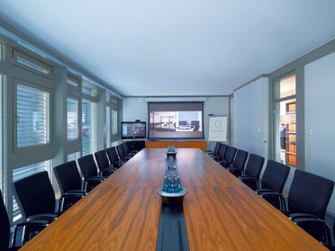 Geräumiger Konferenzraum mit Holztablett und Stühlen