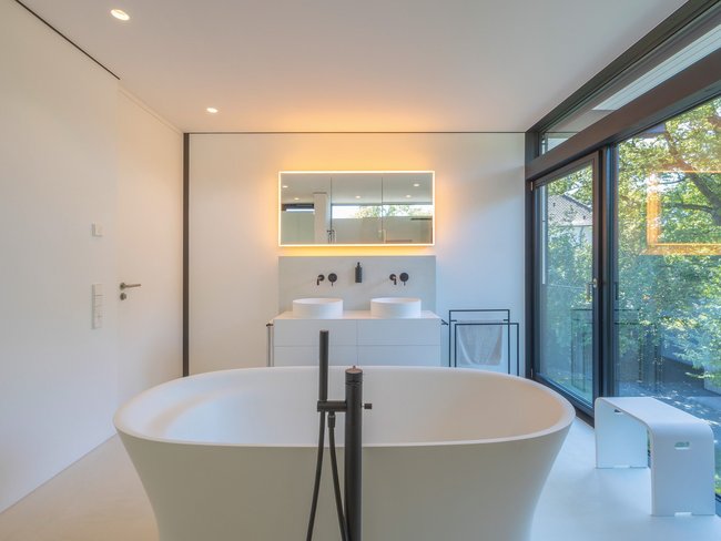 Lichtdurchflutetes Architektenhaus mit modernem Bad Helles Badezimmer mit freistehender Badewanne und Fensterblick