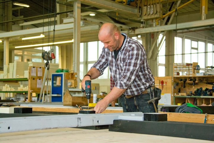 Handwerker bei der Arbeit mit einer Bohrmaschine Mann arbeitet in einer Werkstatt mit einer Bohrmaschine