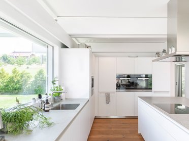 Helle und minimalistische Küche mit Pflanzen und modernen Geräten