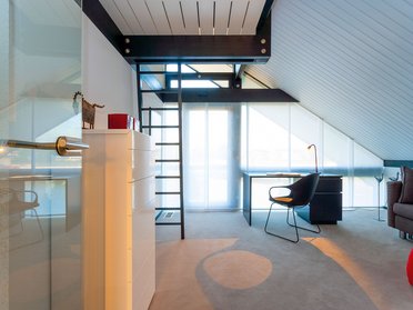 HUF Musterhaus Koblenz ebenholz 8 Heller Raum mit Treppe, Arbeitsbereich und modernem Mobiliar