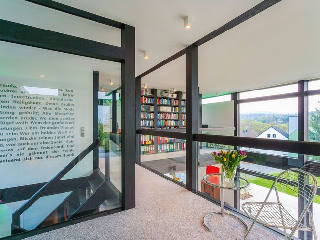 Innenansicht eines modernen Fachwerkhauses mit Flachdach und Bücherregal