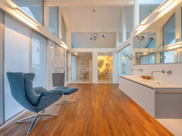Helles Badezimmer mit glatten Wänden, Holzfußboden und elegantem Design.