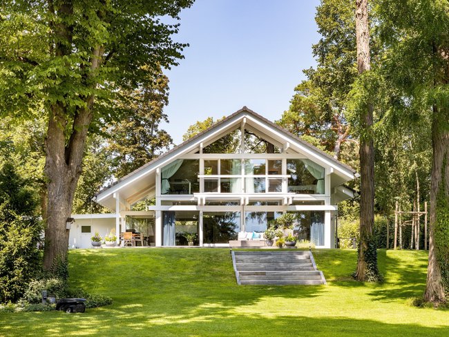 Architektenhaus im Grünen, umgeben von Bäumen und Rasen
