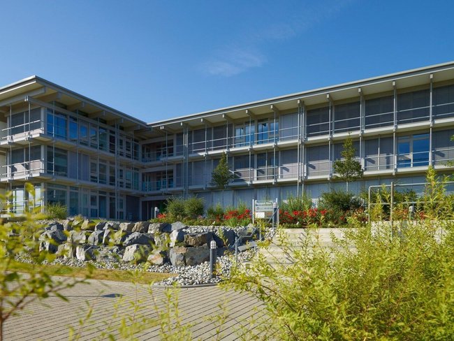 Ansicht des Bürogebäudes HUF mit moderner Fassade und Umgebung