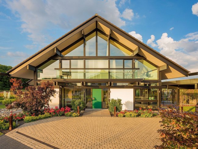 Fassade eines modernen Hauses umgeben von Blumen und Pflanzen
