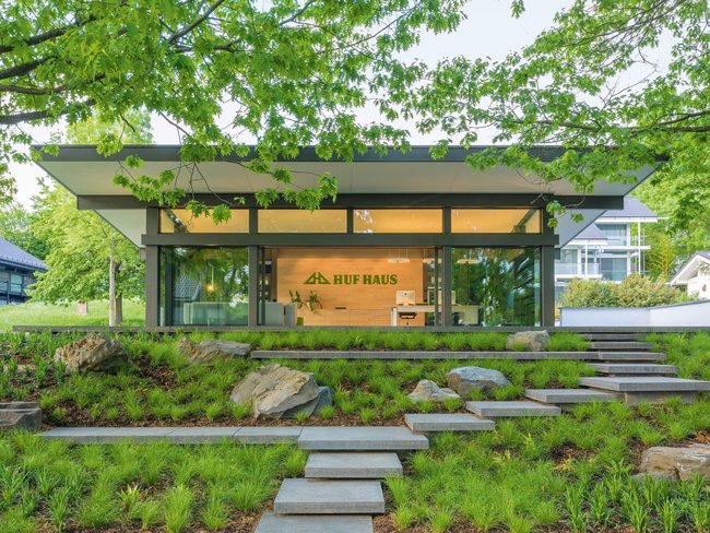 Modernes Huf Haus mit Garten und Steinterrassen Elegante Architektur eines Huf Hauses in einer grünen Umgebung