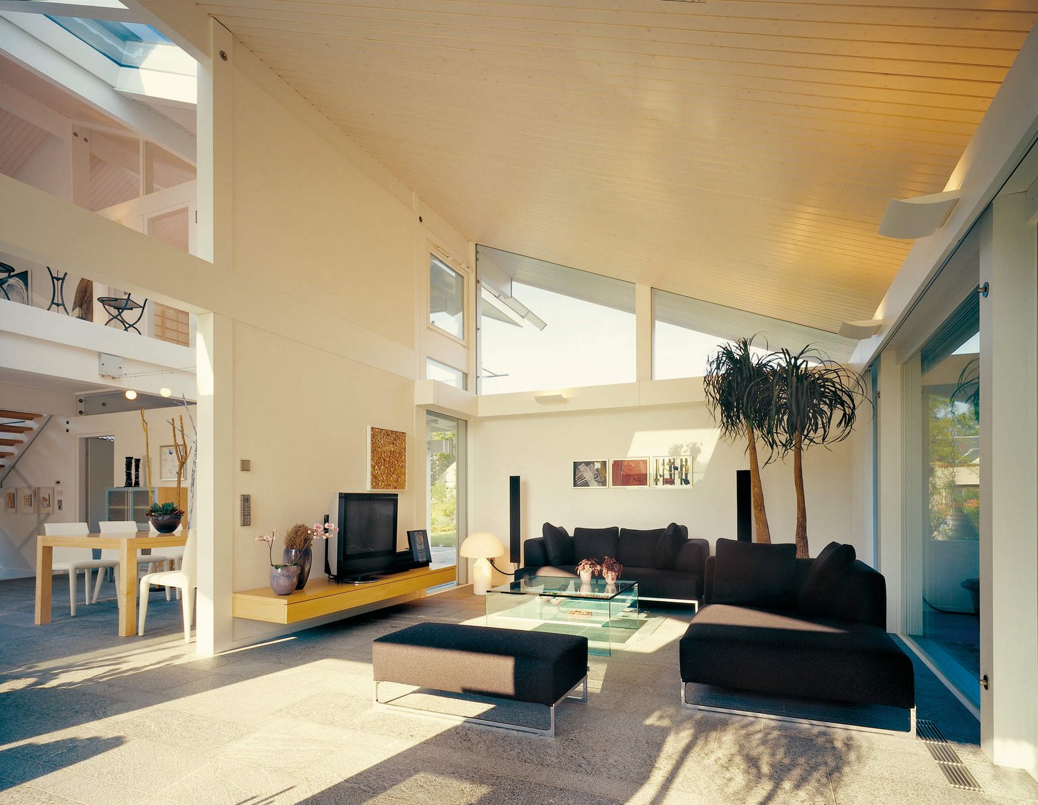 Stilvolles Wohnzimmer mit Sofa, Glas-Tisch und großen Fenstern