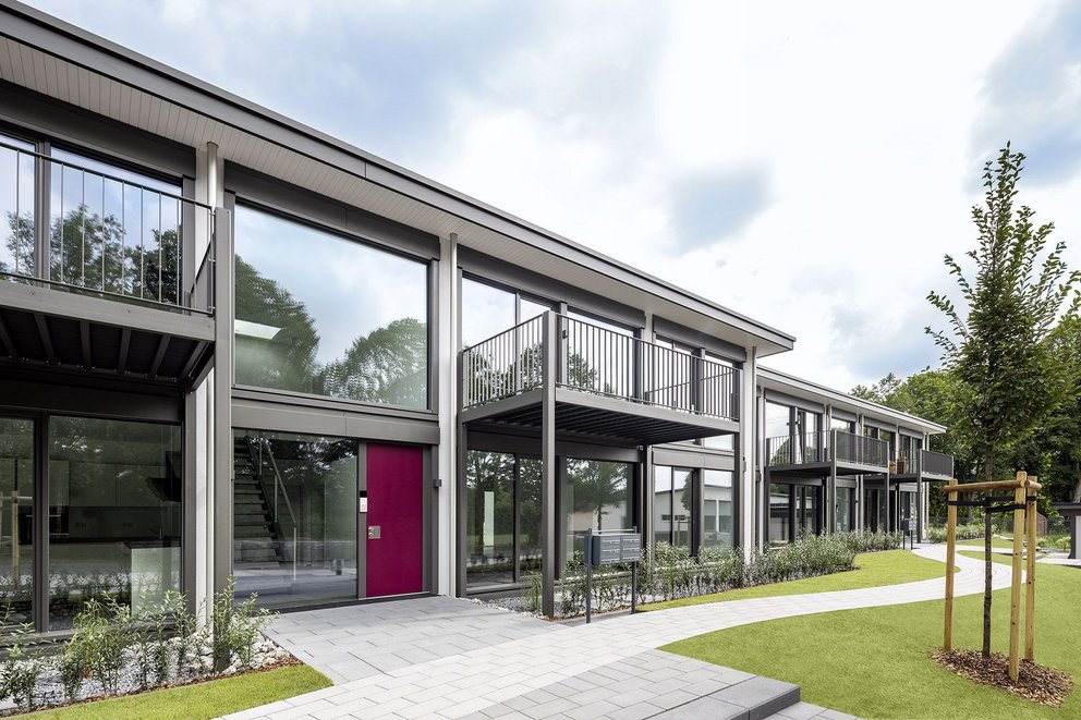Moderne Architektur mit eleganten Balkonen und Grüngestaltung Ansicht eines modernen Gebäudes mit Glasfassade und Balkonen