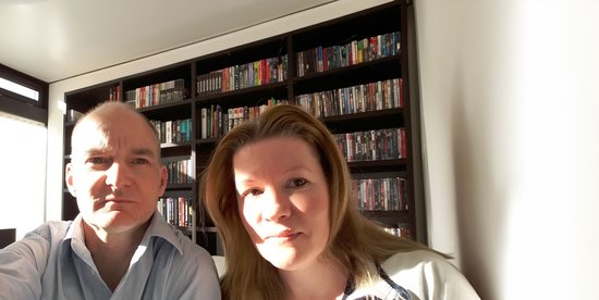 A man and a woman posing for a selfie in a well-lit room