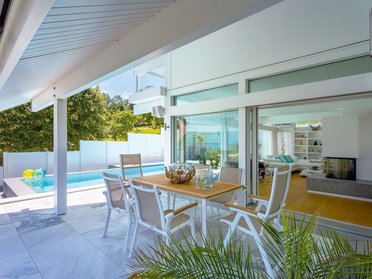 Terrassengarten des Hauses mit Aussicht auf Hügel und See