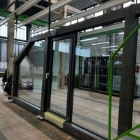 Transparente Glasfront mit Stahlrahmen in einer Fabrikhalle