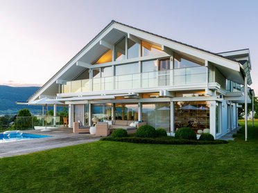 Elegantes Designhaus mit großen Fenstern und einem Pool im Garten