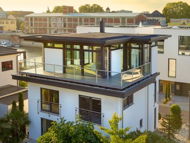 Moderne Architektur eines aufgestockten Hauses mit Glasbalkon