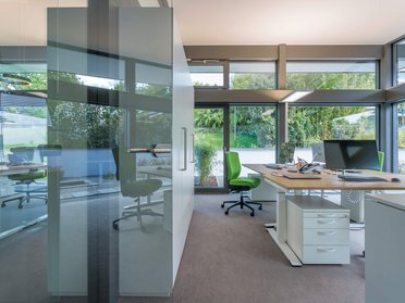 Moderne Büroumgebung mit grünen Stühlen Helle Büros mit Glaswänden und moderner Ausstattung
