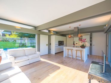 Stilvoller HUF Anbau mit modernem Wohnraum Helles Wohnzimmer mit offener Küche in einem HUF Anbau