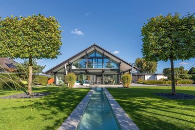 modernes Fachwerkhaus mit Garten und Bachlauf transparentes Fachwerkhaus aus Holz und Glas, Panoramaansicht
