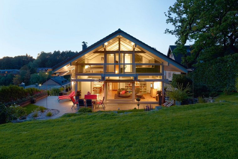 HUF Haus ART 3 grau Fachwerkhaus 11 Offene Bauweise eines HUF Hauses mit Gartenansicht bei Dämmerung