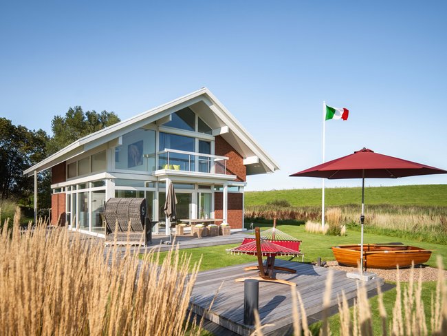 Gemütliches Familienhaus mit Flaggen, Sonnenschirm und Booten