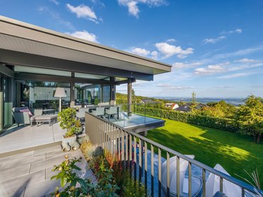 Geräumige Terrasse mit Blick ins Grüne und moderner Architektur