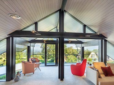 Moderne Wohnraumerweiterung mit Glas- und Holzelementen im Giebel