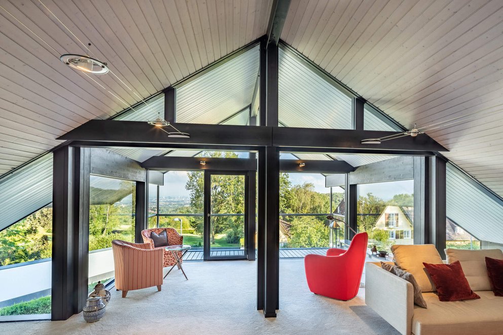 Moderne Wohnraumerweiterung mit Glas- und Holzelementen im Giebel