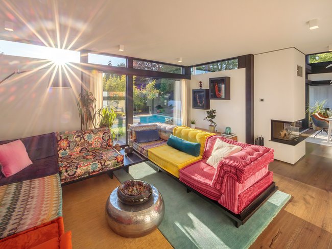 Modernes Designhaus mit Flachdach und Pool Helle, moderne Wohnräume mit bunten Sofas und viel Licht