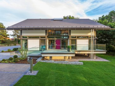 Zeitgenössisches Gebäude mit großzügigen Fensterfronten und Garten