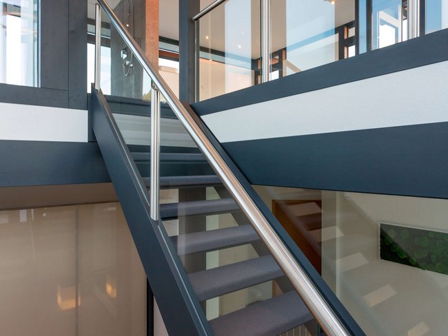Innensicht mit Treppe und Glasgeländer in einem modernen Bestandsgebäude