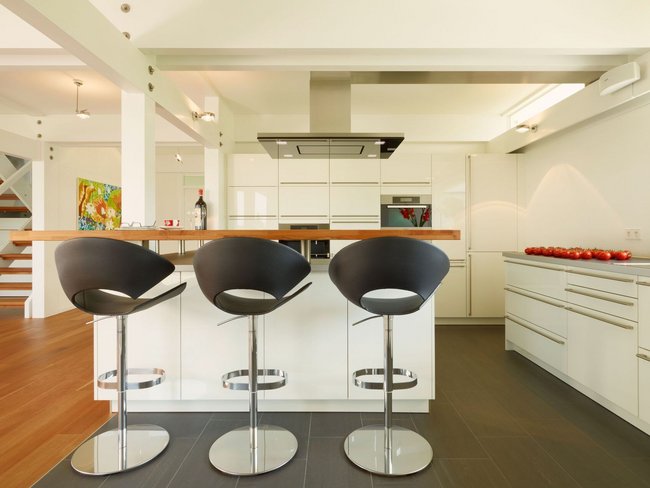 Moderne Küche im Fachwerkhaus HUF HAUS ART 4 Stilvolle Küchenzeile mit Barhockern in einem modernen Wohnraum