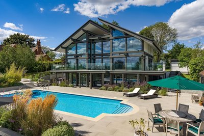 Modernes Fertighaus mit großen Fenstern, Pool und schönen Garten