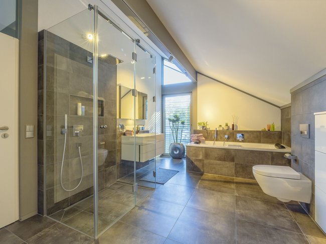 Gemütliches und modernes Badezimmer mit Badewanne und Dusche