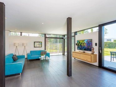 HUF house modum 810 20 Helle Wohnzimmeransicht mit blauen Sofas und moderner Ausstattung