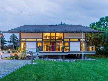 Stilvolles Wohngebäude mit beleuchteten Fenstern und Garten